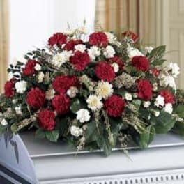 Red and white floral casket spray with greenery