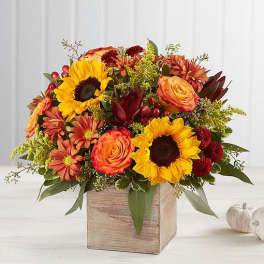 Autumn bouquet of sunflowers, roses, and mums in a wooden box