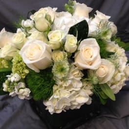 White roses and hydrangeas arranged in a black vase