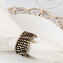 White napkin with a woven napkin ring on a woven placemat