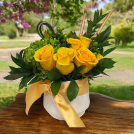 Yellow roses in a white hatbox with a satin ribbon