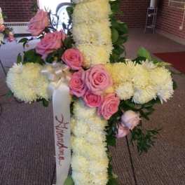 Floral cross arrangement with pink roses and white flowers