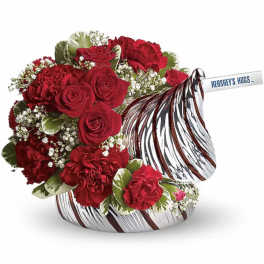 Red roses and carnations in a candy-shaped container with a Hershey's Hugs bar