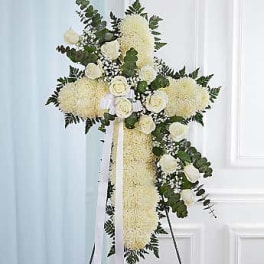 White floral standing cross with ribbon on an easel