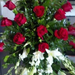 Tall standing arrangement of red roses and white lilies