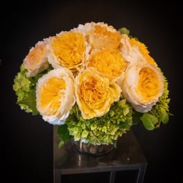 Yellow and white roses arranged in a glass vase