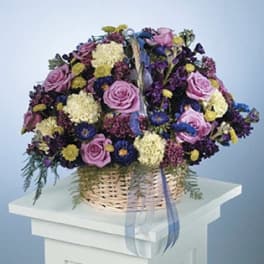 Basket of purple and yellow flowers with pink roses