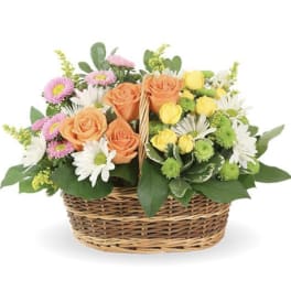 Mixed bouquet of roses, daisies, and mums in a wicker basket