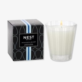 Scented candle in a clear glass tumbler beside its box