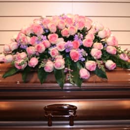 Pink rose casket spray with purple filler flowers