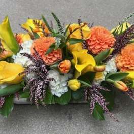 Yellow and orange floral centerpiece with calla lilies and mums