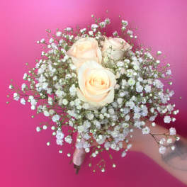 Handheld bouquet of pale peach roses and white baby's breath
