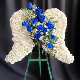White floral heart wreath with blue roses on a stand