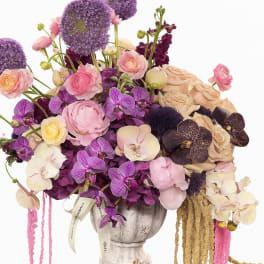 Lavender and pink floral arrangement in a pedestal vase