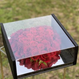 Box of red roses with a mirrored lid outdoors