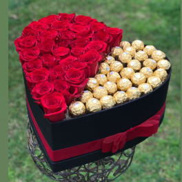 Heart-shaped box of red roses and gold-wrapped chocolates