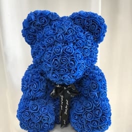 Blue teddy bear made of roses with a black ribbon