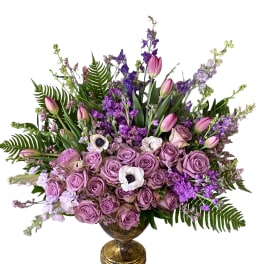 Lavender rose arrangement with pink tulips and purple flowers in a gold vase