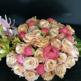 Bouquet of peach roses and pink peonies with green orchids