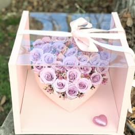 Lavender rose bouquet in a pink gift box with a ribbon bow