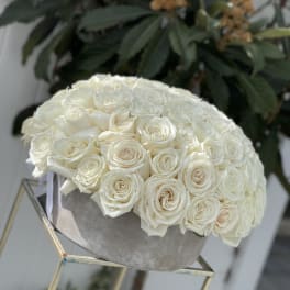 Round bouquet of white roses in a gray box