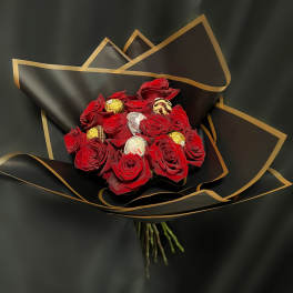 Red rose bouquet with assorted chocolates wrapped in black paper with gold trim