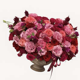 Large pink and red rose arrangement in a pedestal vase