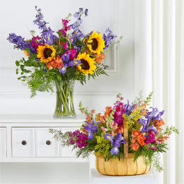 Two colorful flower arrangements with sunflowers and purple blooms, one in a glass vase and one in a basket.