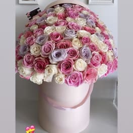 Large round bouquet of pink, white, and lavender roses in a pale pink hat box
