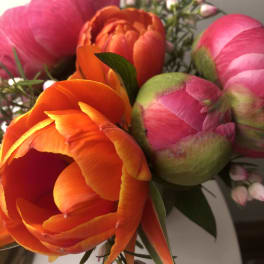 Close-up bouquet of pink and orange tulips with small filler blossoms