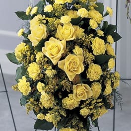 Yellow roses and carnations in a standing floral spray