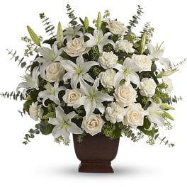 White lilies and roses arranged in a brown urn vase