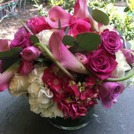 Pink and white bouquet with calla lilies, roses, and hydrangeas in a glass vase