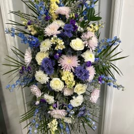 Tall standing floral spray with blue, white, and pink flowers