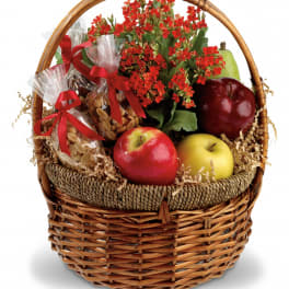 Gift basket with red flowers, apples, pears, and wrapped snacks