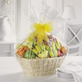 Basket of assorted fruit wrapped in clear cellophane with a yellow bow