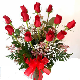 Bouquet of red roses with baby's breath in a glass vase