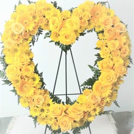 Yellow rose and daisy heart wreath on a black stand