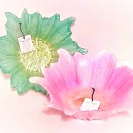 Two decorative glass flower-shaped bowls, one green and one pink