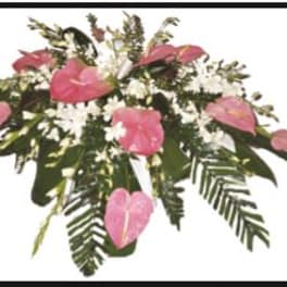 Pink anthuriums and white flowers in a low arrangement