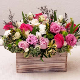 Mixed pink and white flower arrangement in a wooden box