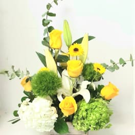 Yellow roses and white lilies in a wooden box with green accents