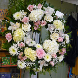 Large floral wreath on an easel with pink and white flowers