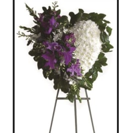 Standing funeral spray with white and purple flowers on an easel