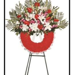 Standing floral wreath with red and white flowers on an easel