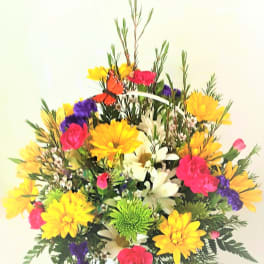 Colorful mixed flower arrangement in a white basket