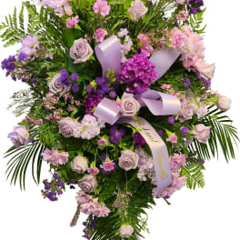 Lavender and pink floral spray with ribbon on a white background