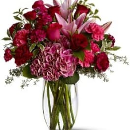 Bouquet of red and pink flowers in a clear glass vase