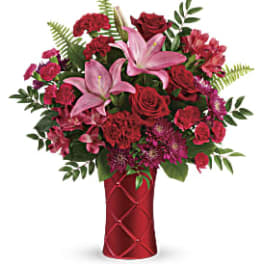 Red and pink mixed bouquet in a red vase