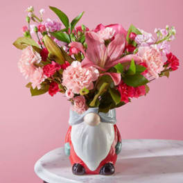 Pink floral arrangement in a Santa-shaped ceramic vase
